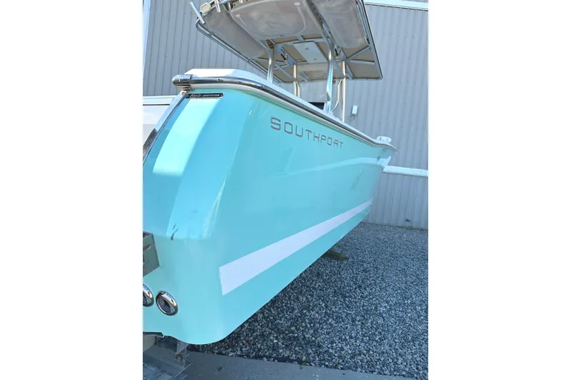Slide: The Image of 2006 Southport 26 Center Console boat with turquoise hull, parked on gravel. - 6