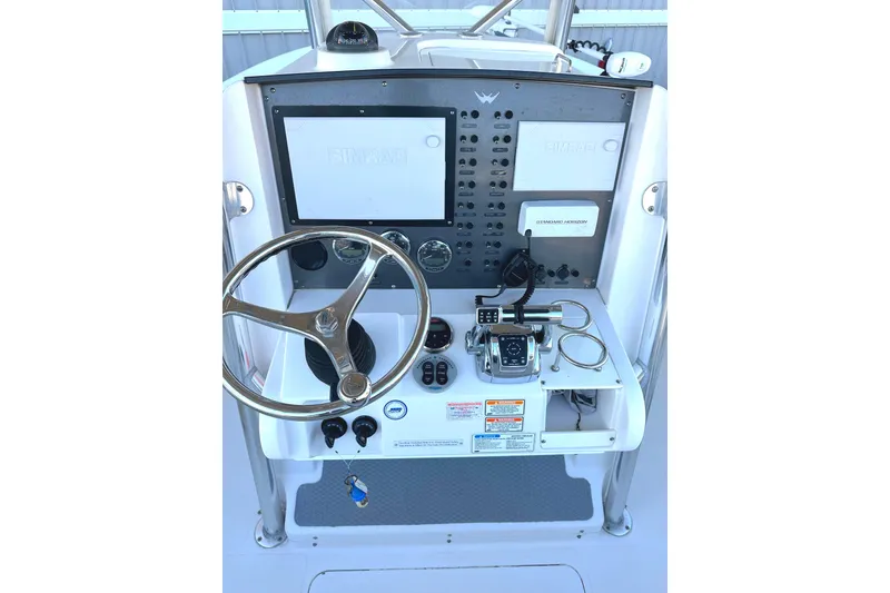 Slide: The Image of 2006 Southport 26 Center Console boat dashboard with steering wheel and navigation controls. - 8