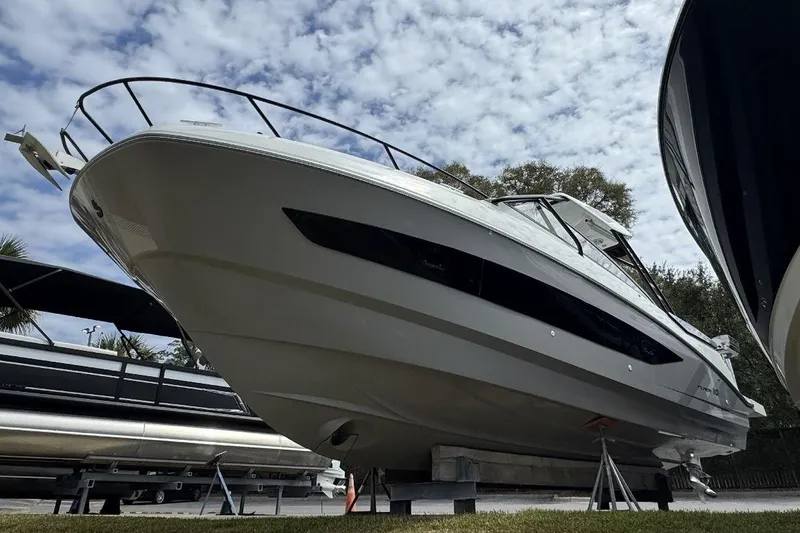 Slide: The Image of 2024 Beneteau Flyer 10 boat displayed outdoors under a partly cloudy sky. - 2