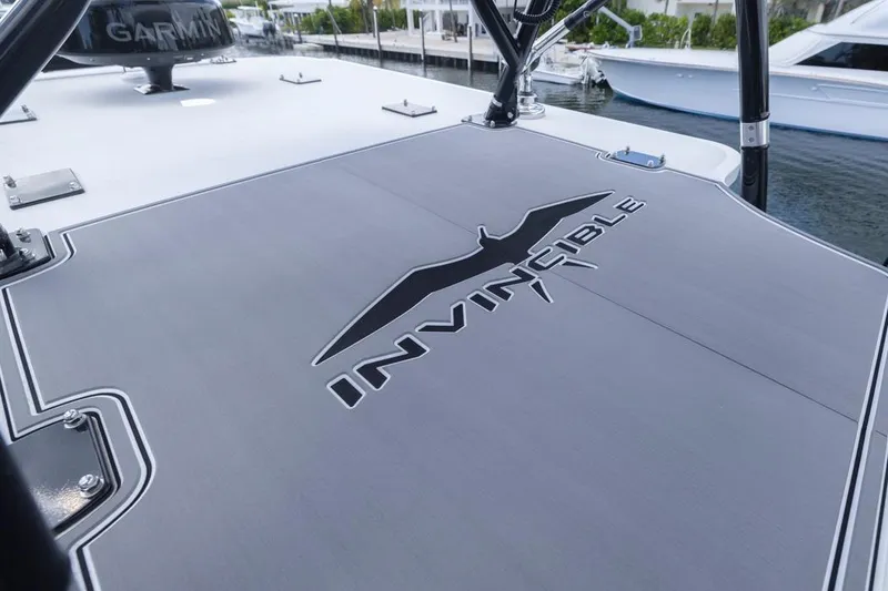 Slide: The Image of 2026 Invincible 36 Catamaran deck with logo, docked near other boats. - 10