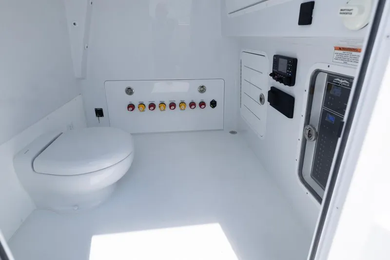 Slide: The Image of Interior of 2026 Invincible 36 Catamaran featuring a modern marine toilet and control panel. - 26
