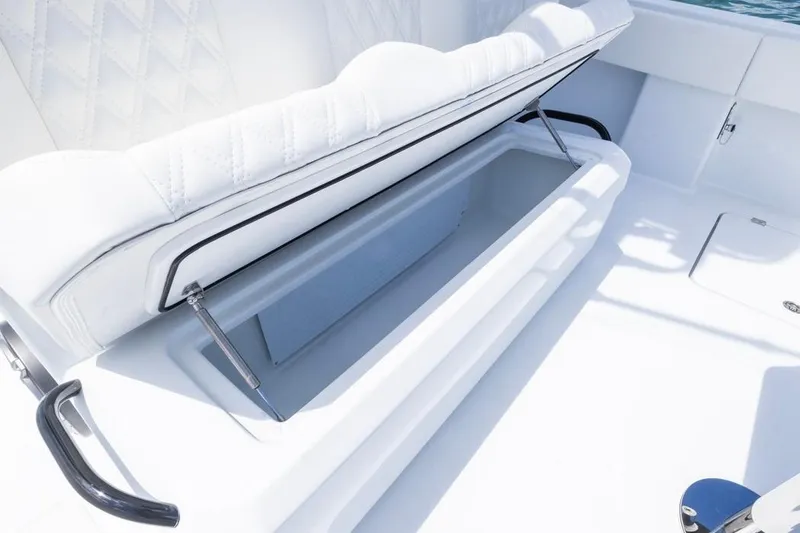 Slide: The Image of 2026 Invincible 36 Catamaran storage compartment with cushioned seating, open on a sunny day. - 39