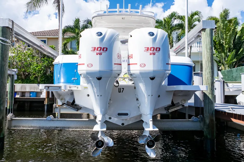Slide: The Image of 2015 Intrepid 327 Cuddy with twin Yamaha 300 V6 engines docked by palm trees. - 11