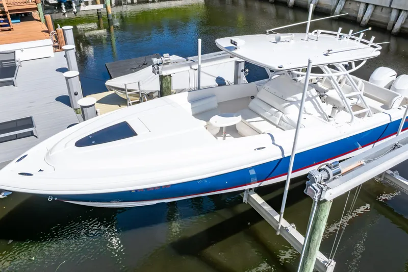 Slide: The Image of 2015 Intrepid 327 Cuddy boat docked, featuring sleek design and spacious deck. - 12