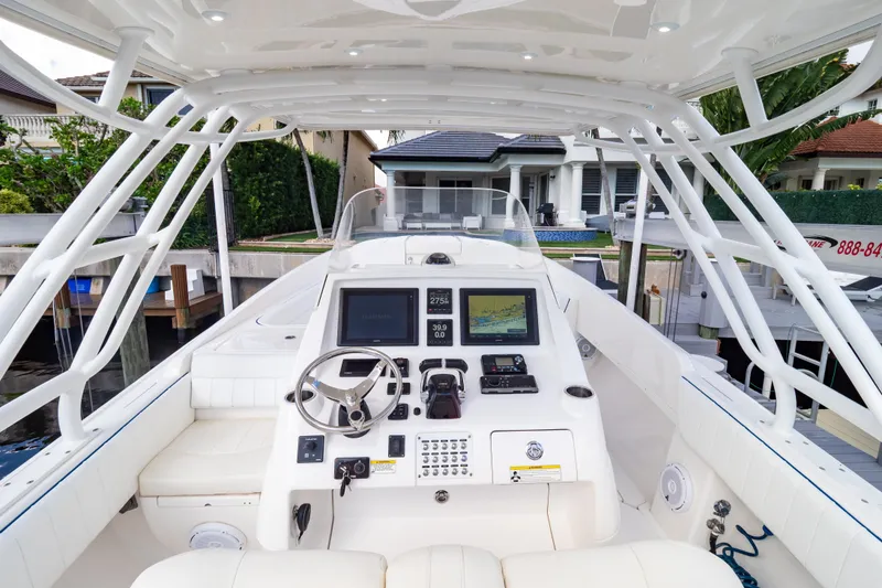 Slide: The Image of 2015 Intrepid 327 Cuddy boat cockpit with steering wheel and navigation displays. - 13