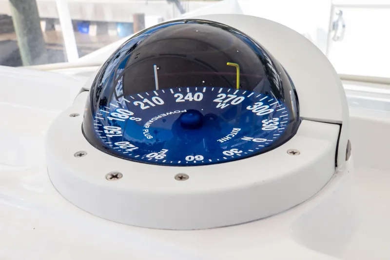 Slide: The Image of Compass on 2015 Intrepid 327 Cuddy boat, displaying navigational directions. - 18