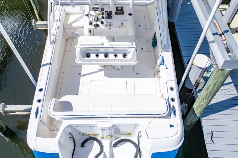 Slide: The Image of 2015 Intrepid 327 Cuddy boat docked, showcasing spacious deck and seating area. - 25