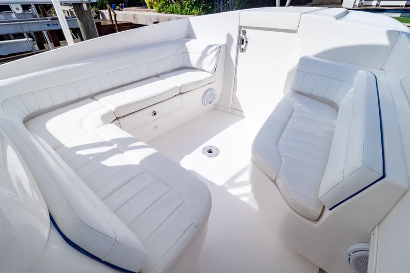 Slide: The Image of 2015 Intrepid 327 Cuddy boat interior with white cushioned seating. - 3