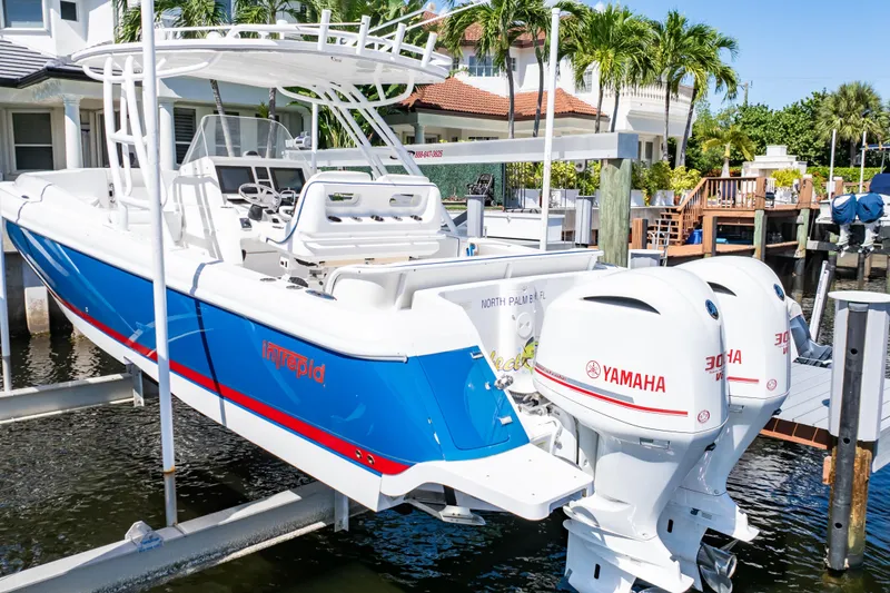 Slide: The Image of 2015 Intrepid 327 Cuddy boat with Yamaha engines docked near waterfront home. - 30