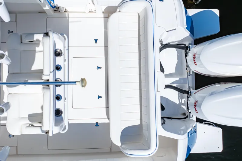 Slide: The Image of 2015 Intrepid 327 Cuddy boat interior with seating and dual outboard engines. - 32