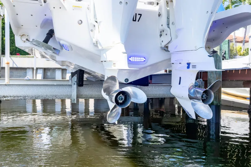 Slide: The Image of 2015 Intrepid 327 Cuddy boat with dual outboard motors above water. - 35