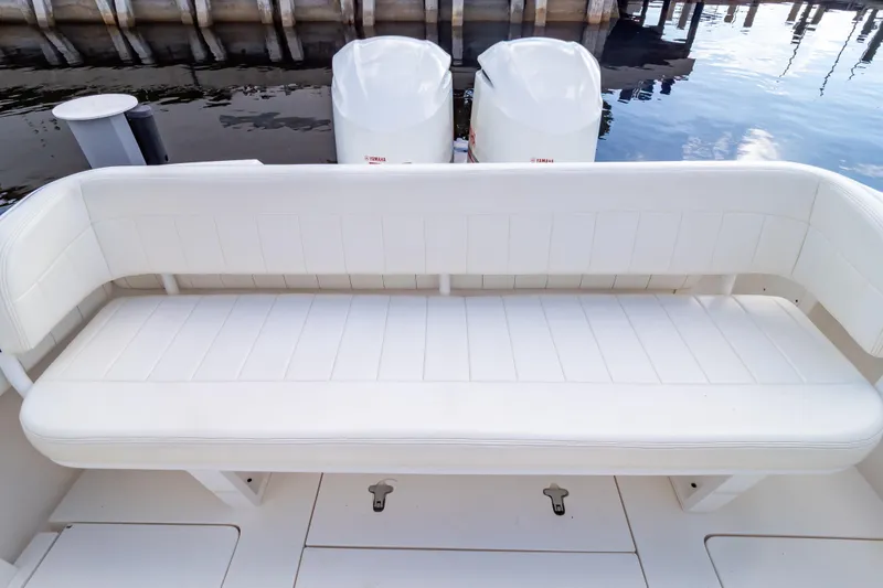 Slide: The Image of 2015 Intrepid 327 Cuddy boat with white cushioned seating and dual outboard motors. - 38