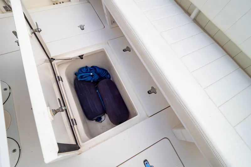 Slide: The Image of 2015 Intrepid 327 Cuddy boat storage compartment with fenders and rope. - 43