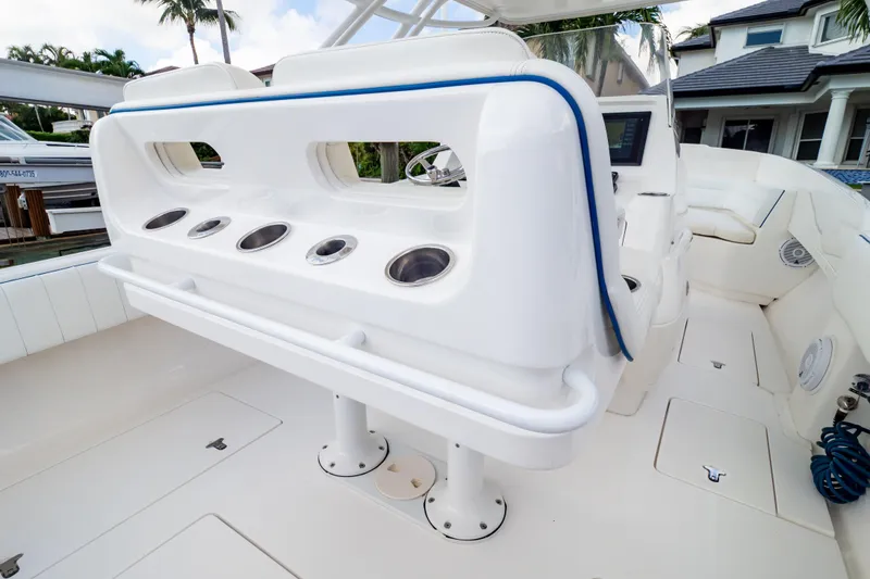 Slide: The Image of 2015 Intrepid 327 Cuddy boat interior with rod holders and seating area. - 45
