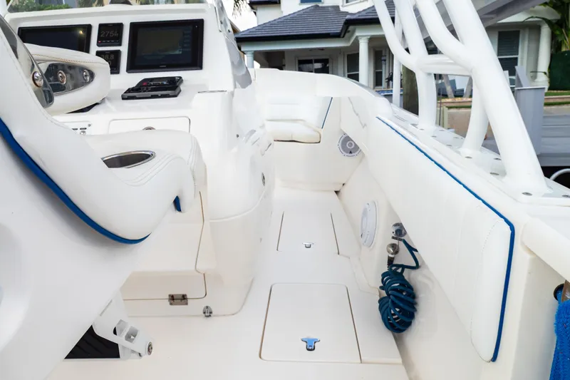 Slide: The Image of 2015 Intrepid 327 Cuddy interior with white seating and modern dashboard controls. - 46
