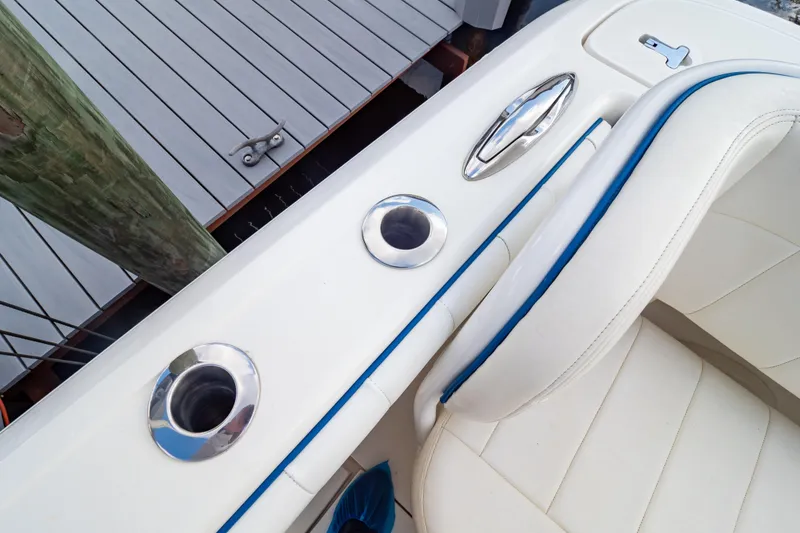 Slide: The Image of 2015 Intrepid 327 Cuddy boat interior with white seating and stainless steel fixtures. - 48