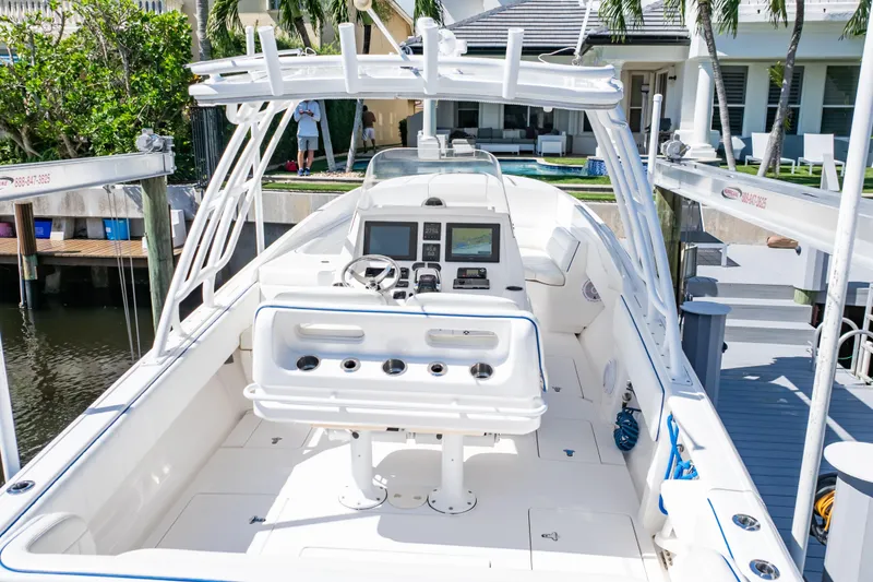 Slide: The Image of 2015 Intrepid 327 Cuddy boat docked, featuring a spacious cockpit and modern controls. - 5