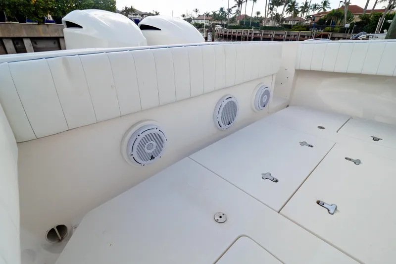 Slide: The Image of 2015 Intrepid 327 Cuddy boat interior with white seating and built-in speakers. - 51