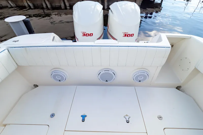 Slide: The Image of 2015 Intrepid 327 Cuddy boat with twin Yamaha 300 engines, white seating, and speakers. - 52