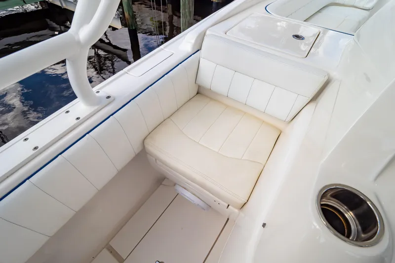 Slide: The Image of 2015 Intrepid 327 Cuddy boat interior with white cushioned seating. - 53