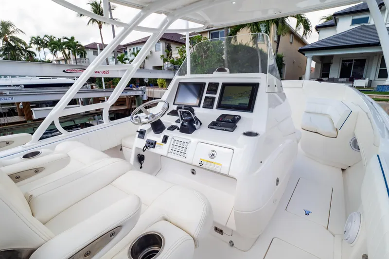 Slide: The Image of 2015 Intrepid 327 Cuddy boat interior with modern navigation system and white seating. - 55