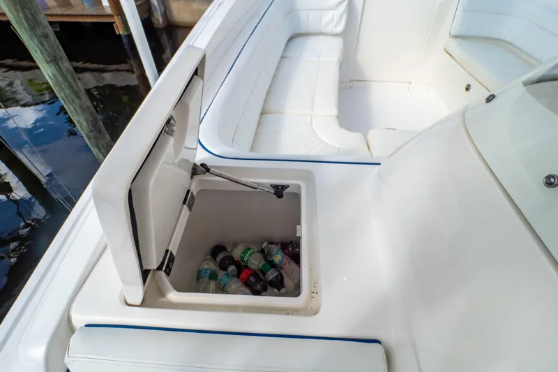 Slide: The Image of 2015 Intrepid 327 Cuddy boat with open cooler and white seating. - 59