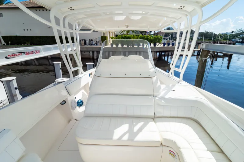 Slide: The Image of 2015 Intrepid 327 Cuddy boat interior with white seating and waterfront view. - 64