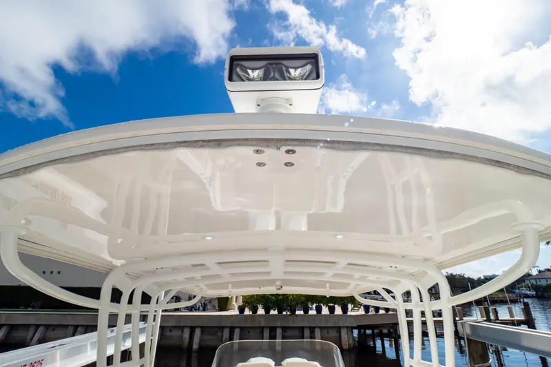 Slide: The Image of 2015 Intrepid 327 Cuddy boat with sleek white canopy under blue sky. - 65