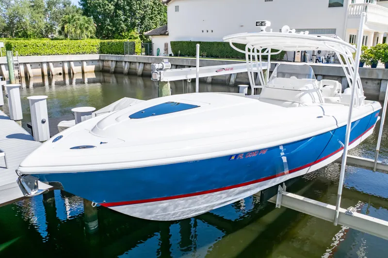 Slide: The Image of 2015 Intrepid 327 Cuddy boat docked in a marina, featuring a sleek blue and white design. - 7