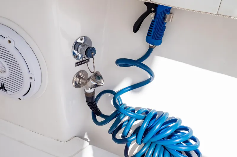 Slide: The Image of 2015 Intrepid 327 Cuddy boat with blue coiled hose and speaker detail. - 70