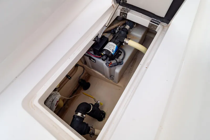 Slide: The Image of 2015 Intrepid 327 Cuddy boat compartment with pump and plumbing system. - 72