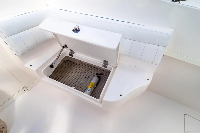 Slide: The Image of Open storage compartment on 2015 Intrepid 327 Cuddy boat with fire extinguisher inside. - 73