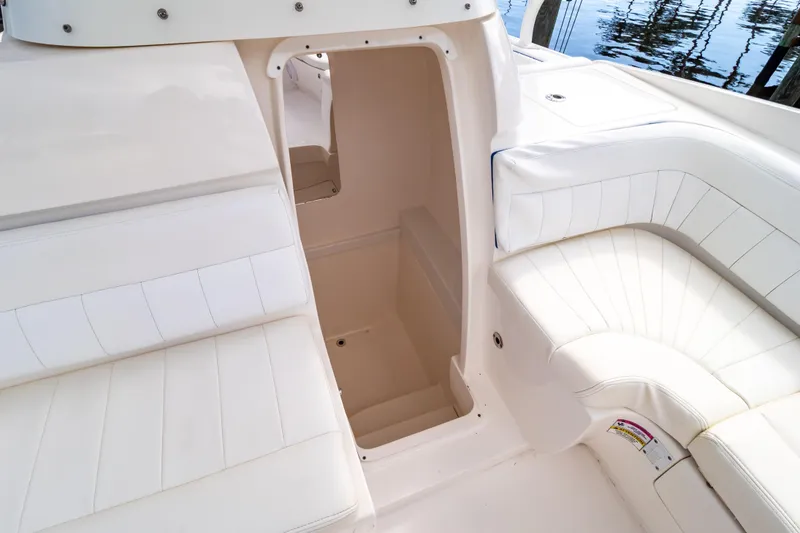 Slide: The Image of 2015 Intrepid 327 Cuddy interior with white seating and open cabin entrance. - 74