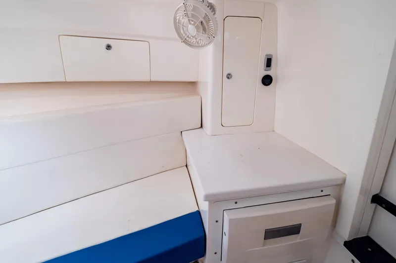 Slide: The Image of Interior of a 2015 Intrepid 327 Cuddy boat with seating and storage compartments. - 77