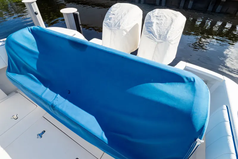 Slide: The Image of 2015 Intrepid 327 Cuddy boat with blue cover and twin engines. - 89