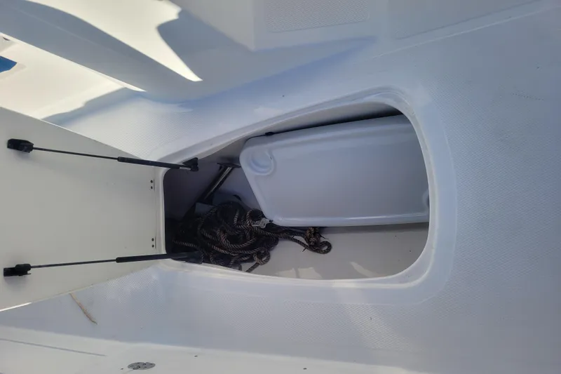 Slide: The Image of Open storage compartment on 2017 Tahoe 2150 boat with coiled rope inside. - 16