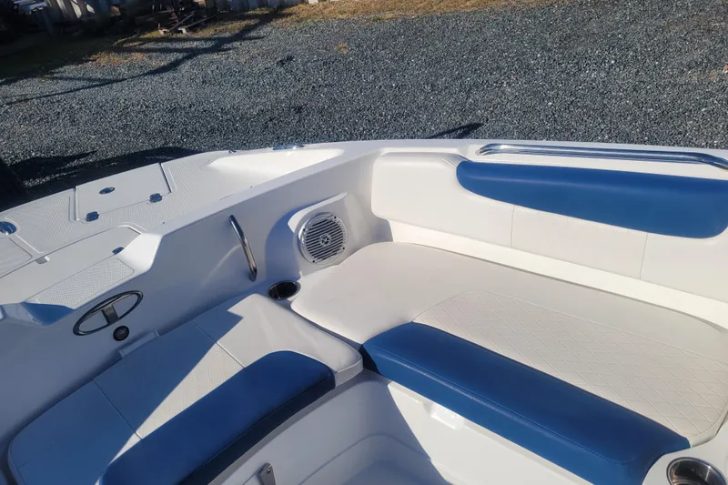Slide: The Image of 2017 Tahoe 2150 boat interior with blue and white seating, speaker, and cup holder. - 18