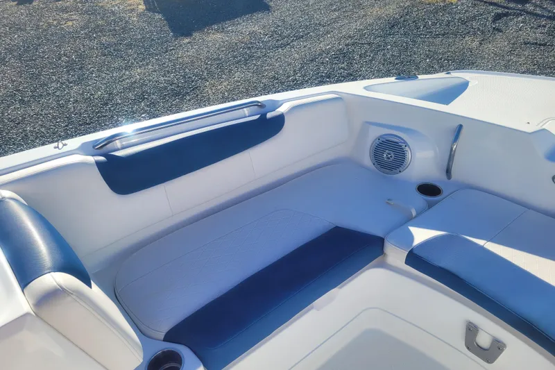 Slide: The Image of 2017 Tahoe 2150 boat interior with blue and white seating, speaker, and cup holder. - 19