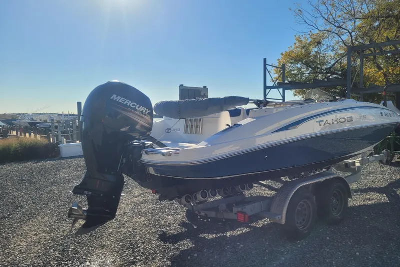 Slide: The Image of 2017 Tahoe 2150 boat with Mercury engine on a trailer, parked outdoors. - 4
