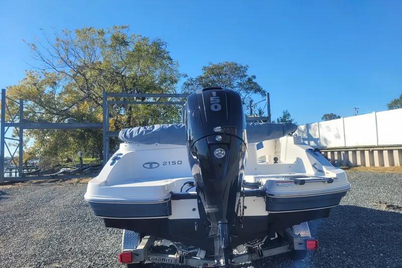 Slide: The Image of 2017 Tahoe 2150 boat with outboard motor on a trailer, parked outdoors. - 5