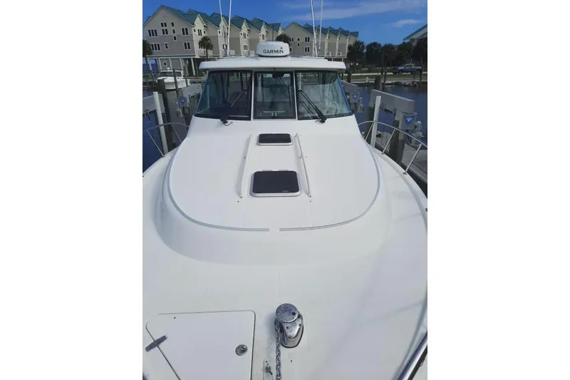 Slide: The Image of 2015 Pursuit OS 385 Offshore boat on dry dock under clear blue sky. - 1