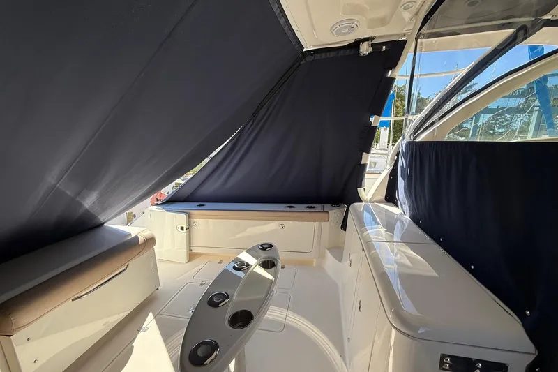 Slide: The Image of 2015 Pursuit OS 385 Offshore boat interior with seating and covered windows. - 10