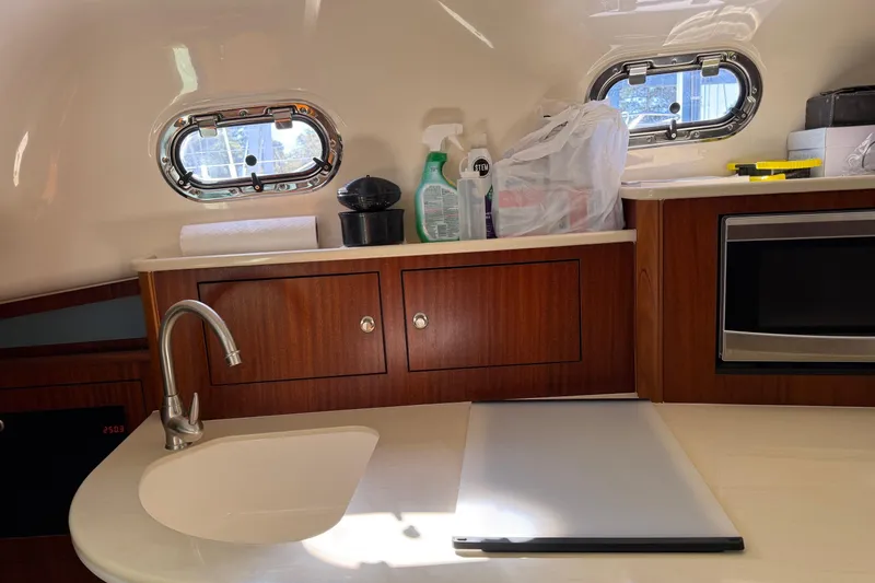 Slide: The Image of Kitchen area of 2015 Pursuit OS 385 Offshore boat with sink and microwave. - 13