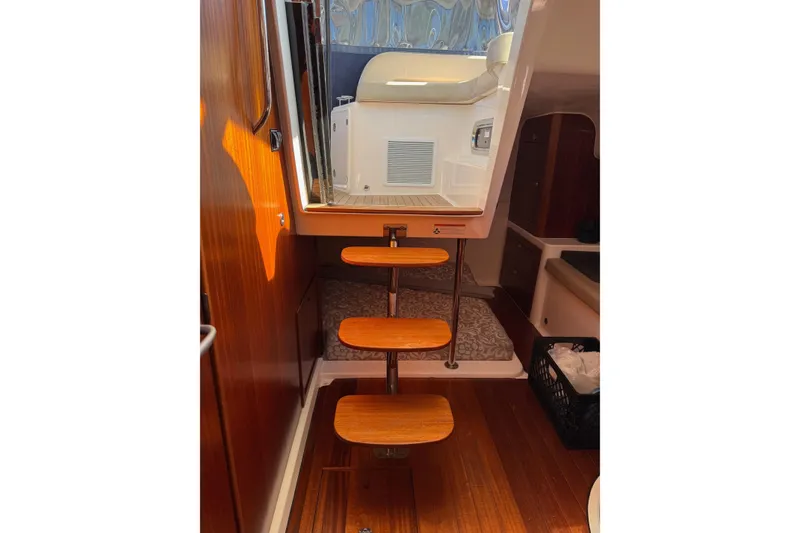 Slide: The Image of Interior view of 2015 Pursuit OS 385 Offshore boat with wooden steps and cozy cabin. - 15