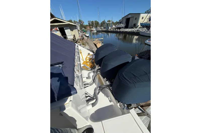 Slide: The Image of 2015 Pursuit OS 385 Offshore boat docked, featuring covered engines and marina view. - 16