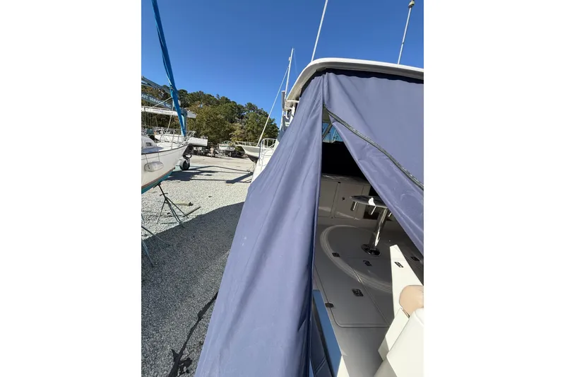 Slide: The Image of 2015 Pursuit OS 385 Offshore boat with blue cover, docked outdoors. - 17