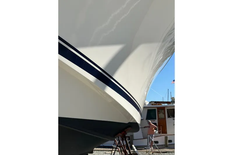 Slide: The Image of 2015 Pursuit OS 385 Offshore boat in dry dock, with a person nearby. - 5