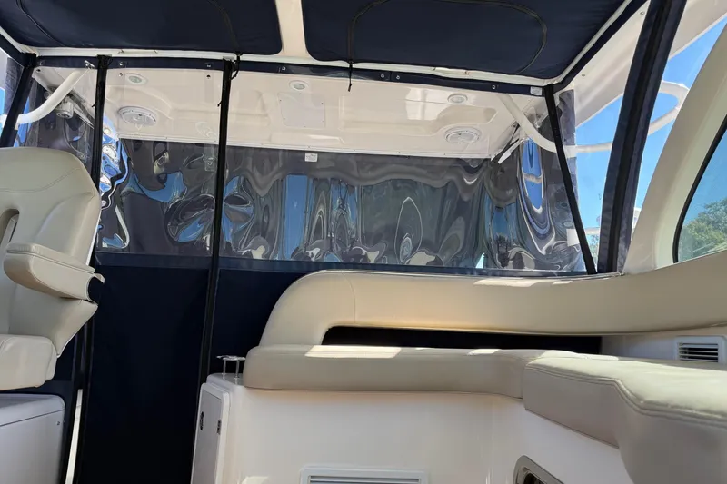Slide: The Image of 2015 Pursuit OS 385 Offshore boat interior with seating and canopy. - 9