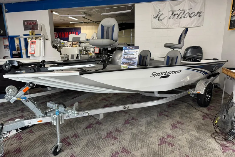 The Image of 2025 G3 Sportsman 1610 boat on display in showroom with trailer and Yamaha motor. - 0
