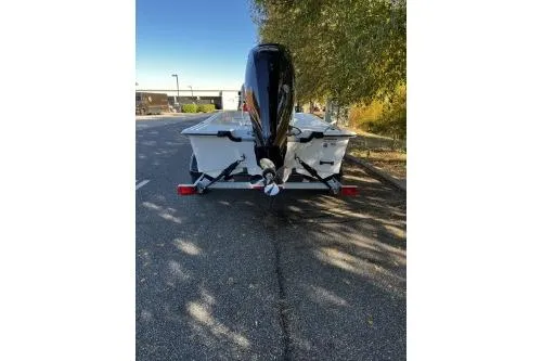 Slide: The Image of 2026 Mako Pro Skiff 17 CC boat on trailer, parked on a sunny street. - 3